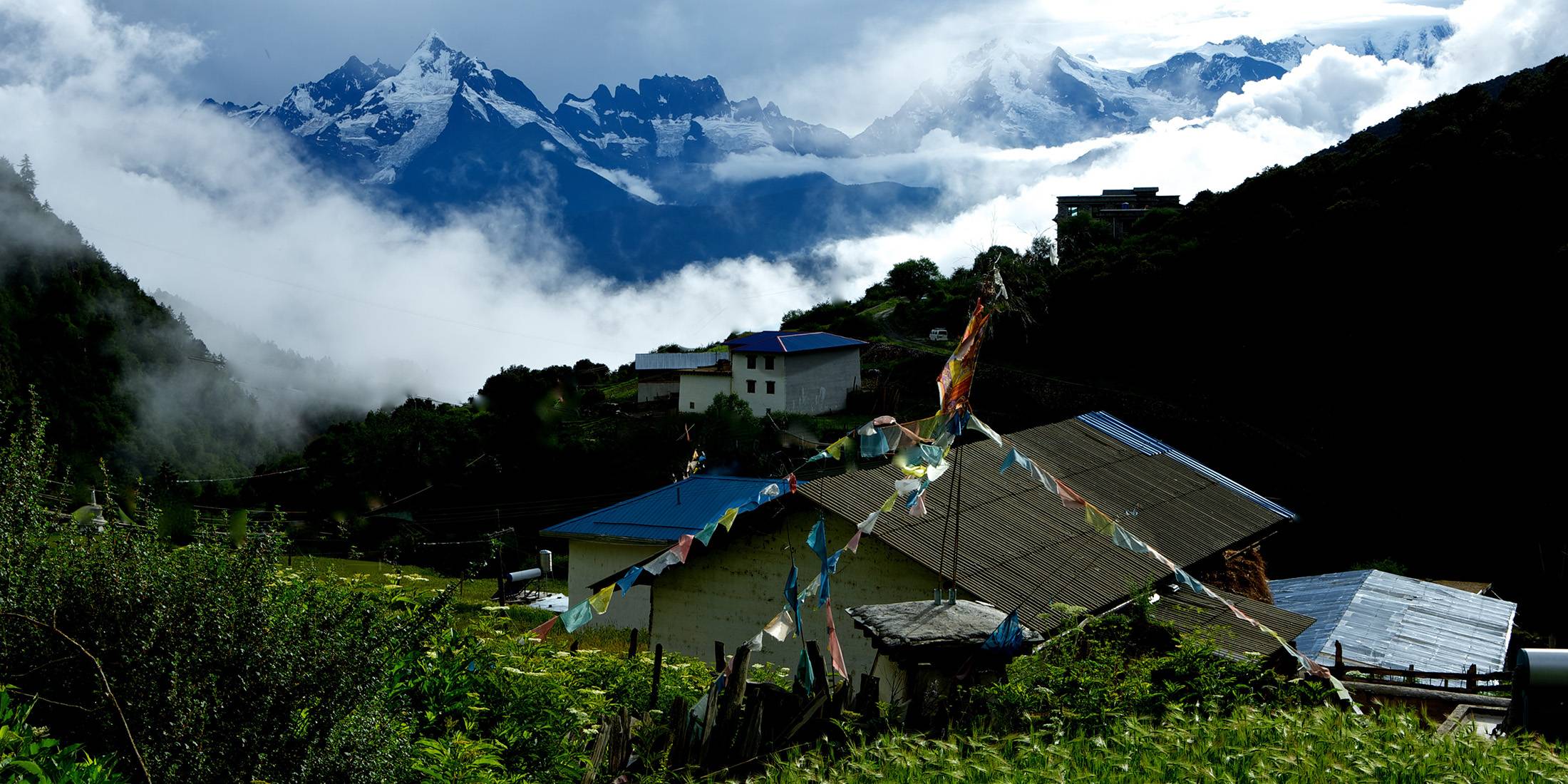 Gujiunong village beneath misted ridges of the Meili Snow Mountains